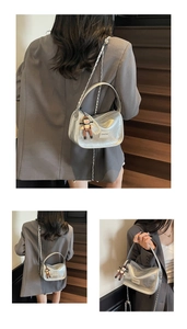 Détail du sac oreiller argenté métallisé avec chaîne en perles et breloque poupée