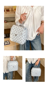 Close-up of light blue polka dot backpack with silver twist lock and chain strap