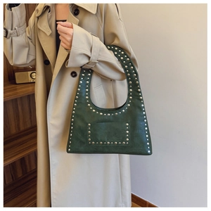Detail of dark green rivet hobo bag showing matte leather texture and punk studs