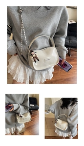 Détail du sac en cuir verni blanc avec chaîne en métal et breloque poupée de dessin animé