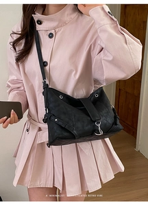Close-up of minimalist black matte leather tote bag with silver hardware on a model
