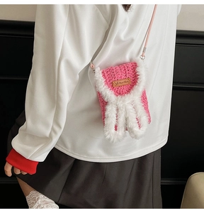 Detail of pink crochet mini bag with plush rabbit ears and a brown Hand Made leather label