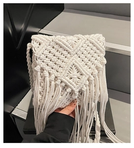 Detalle de bolso bandolera de macramé bohemio con flecos blancos y correa tejida