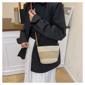 Detail of hand-woven bucket bag with brown stripes and golden metal clasps for summer