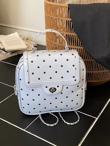 Chic light blue polka dot backpack with chain strap on monochrome tiles