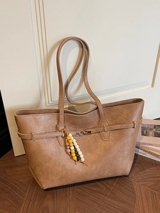 Brown faux leather tote bag with metal lock buckle and colorful wooden bead tassel charm
