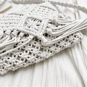 Primer plano del bolso bohemio de ganchillo con flecos y correa de hombro gruesa crema