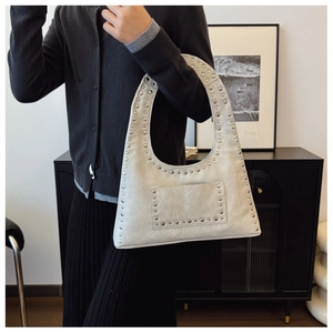 Detail shot of vintage silver rivet shoulder bag with textured oil wax leather and moon shape