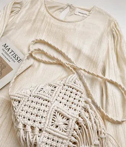 Detalle de bolso de hombro blanco hecho a mano a ganchillo con flecos largos y correa