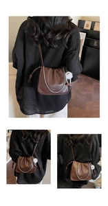 Détail du sac seau plissé marron foncé avec chaîne argentée et breloque en peluche