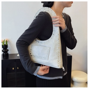Silver-grey rivet shoulder bag with vintage leather texture shown on female model
