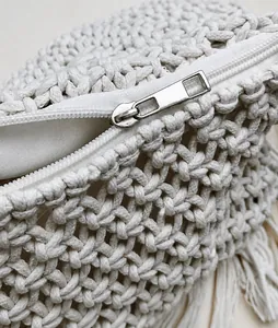 Detalle de cremallera metálica lisa y textura tejida del bolso de ganchillo blanco