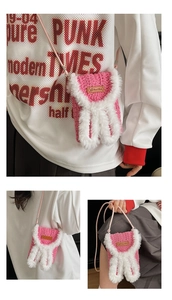 Detailed view of pink crochet phone bag with white bunny ears and handmade leather tag