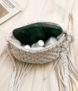 Vista de detalle del bolso de hombro tejido con borlas y forro interior amplio