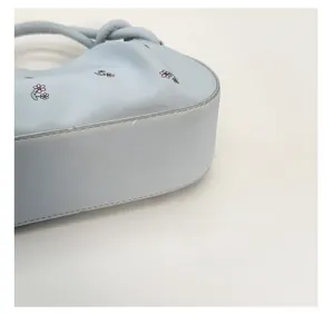 Detailed close-up showing the structured bottom and stitching of the floral handbag