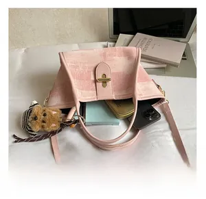 Internal capacity of pink woven bucket bag with phone and small dog charm detail