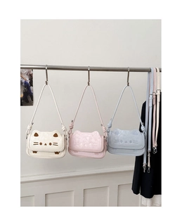 Close-up of three cute cat-themed crossbody bags in white, pink, and blue with 3D ears