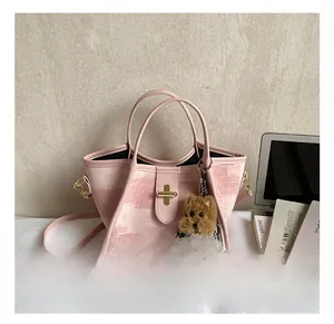 Detailed pink textured bucket bag featuring gold metal clasp and a cute plush puppy charm