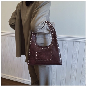 Detail of vintage burgundy tote with silver studs and small front pocket on strap