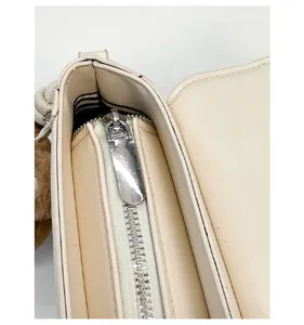 Detail view of smooth metal zipper and striped fabric lining inside a cat crossbody bag