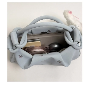 Light blue floral shoulder bag showing large interior space for phone and cosmetics