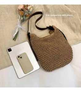 Size comparison of woven shoulder bag with a tablet and phone on beige fabric