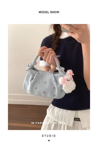 Blue dumpling bag with floral embroidery and a white plush rabbit charm on the side