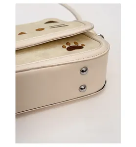 Close-up of beige cat theme purse base with silver rivets and reinforced stitching