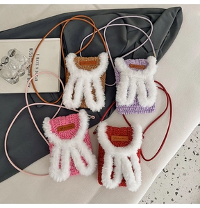 Detail of handmade crochet bunny ear crossbody bags in four vibrant colors with long straps