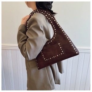 Detail showing vintage dark brown oil wax leather and silver rivet studs on shoulder bag