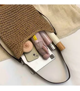 Top-down view of woven tote bag showing large capacity with essentials like tablet and umbrella