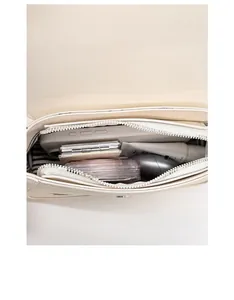 Interior view of small square bag showing dual compartments and striped lining storage