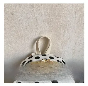 Dettaglio del manico in pelle e della doppia zip dorata sullo zaino a pois