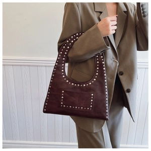 Detail view of deep red oil wax leather hobo bag with vintage silver studs and rivets