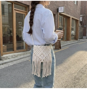Detalle de bolso bohemio de punto con motivos calados y flecos largos decorativos