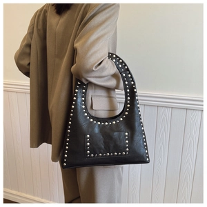 Detail of vintage black rivet shoulder bag with silver studs and circular handle