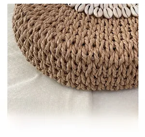 Gros plan d'un sac en paille tressée avec des décorations de coquillages blancs sur le bord