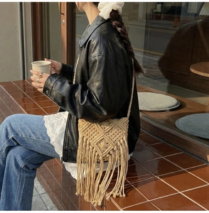 Detalle de bolso bandolera de tejido beige bohemio con flecos en un entorno exterior
