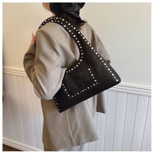 Detail view of black punk leather shoulder bag with vintage silver metal rivet decorations