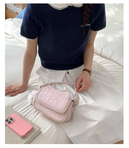 Detail of pink cat crossbody bag with facial embroidery and 3D ears for casual style