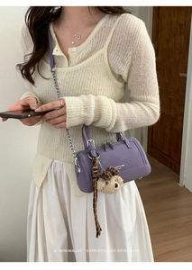 Détail du sac bowling en cuir violet avec breloque ours et foulard à rayures