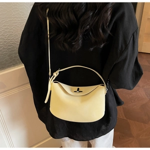 Détail d'un sac Lindy en cuir jaune crème avec poignée supérieure et fermoir pivotant