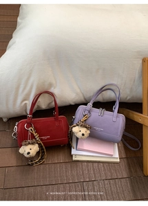 Mini sacs à main bowling rouge et violet avec porte-clés ours sur sol en bois