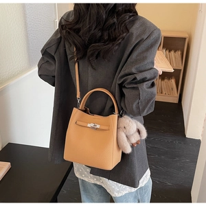 Secchiello in pelle beige con chiusura argento e ciondolo a coniglio su modella