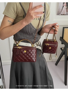 Quilted burgundy mini bag detail with golden camellia lock and chain strap