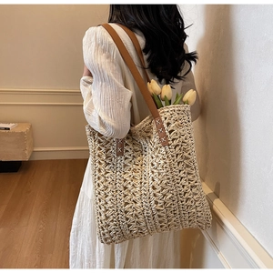 Detail of hand-woven beige tote bag with brown PU shoulder strap and large capacity