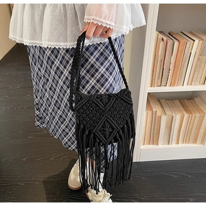 Detalle de bolso negro de macramé con flecos bohemios y patrón de rombos