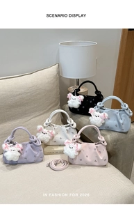 Detail view of colorful pleated cloud dumpling bags with cute plush rabbit charms on a sofa