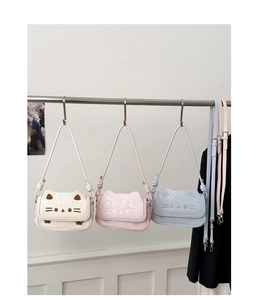 Detailed view of cute cat-shaped crossbody bags in white, pink, and light blue colors