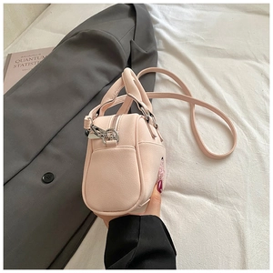 Sac à main rose en cuir grainé avec fermeture éclair argentée et bandoulière amovible
